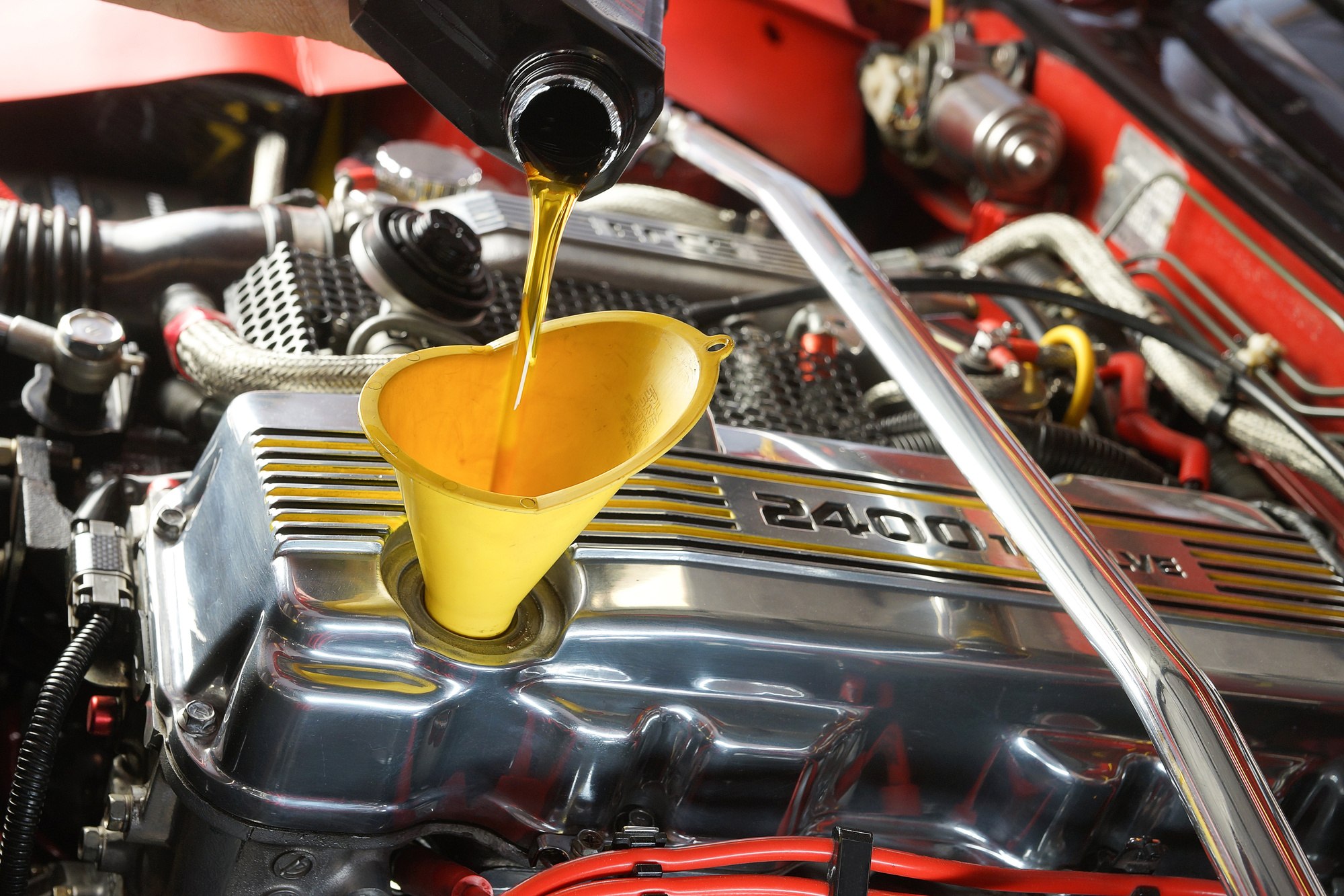 Fresh oil being poured into an engine through a funnel
